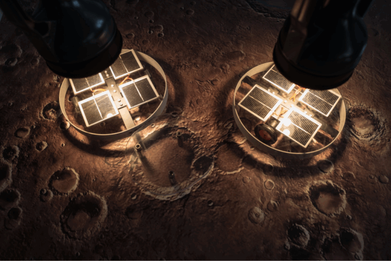 Zwei runde Solarpaneele mit quadratischen Zellen auf unebenem, kraterübersätem Boden unter zwei Lampen.