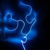 Leuchtende, blaue, geschwungene Linie vor dunklem Hintergrund